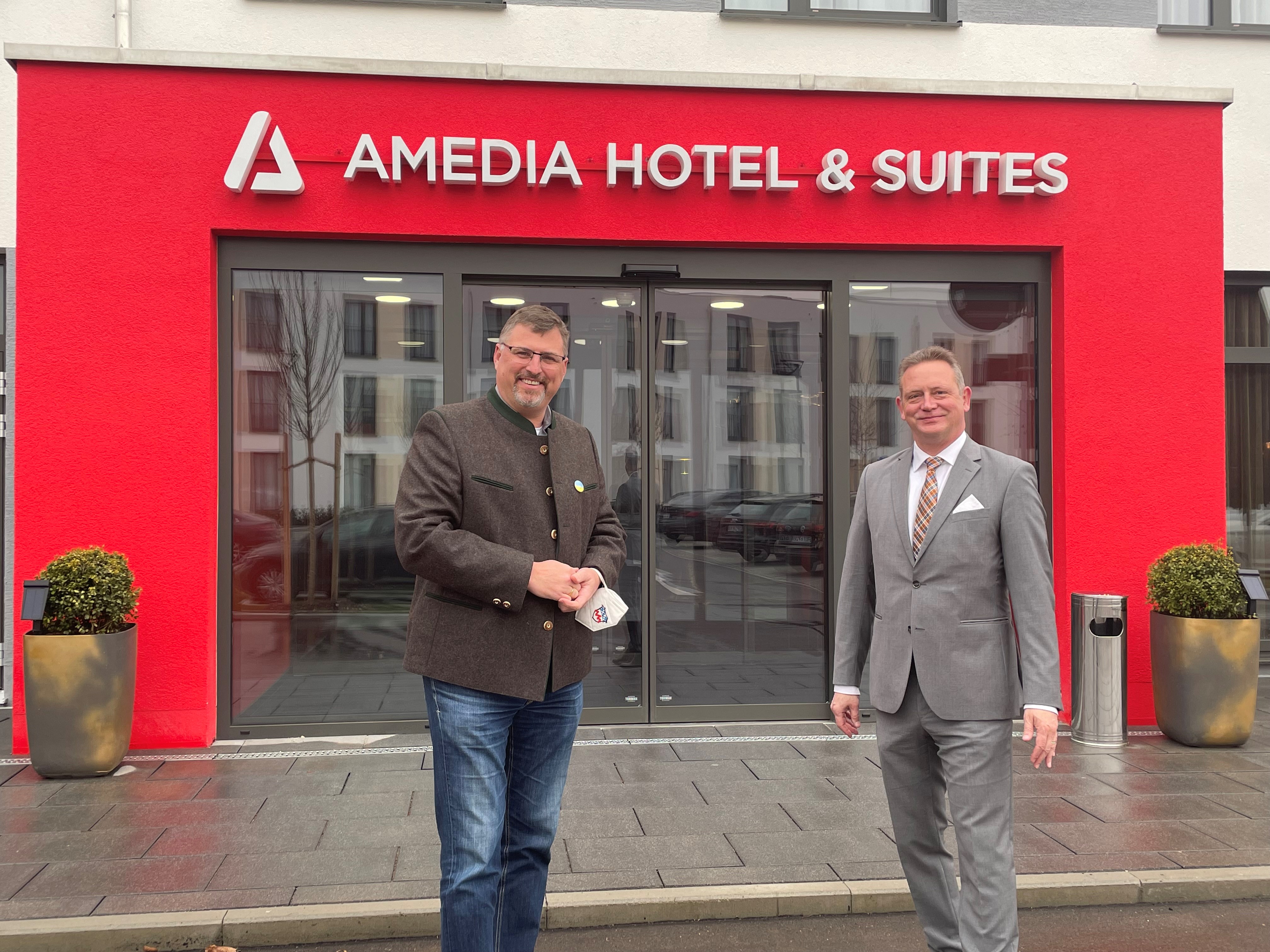 Landrat Stefan Löwl bedankt bei dem Hoteldirektor des Amedia Hotel & Suites Henning Michel