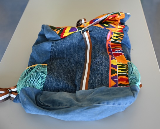 Ein bunter Rucksack aus gebrauchtem, recyceltem Jeansstoff mit praktischen Fächern und Taschen.