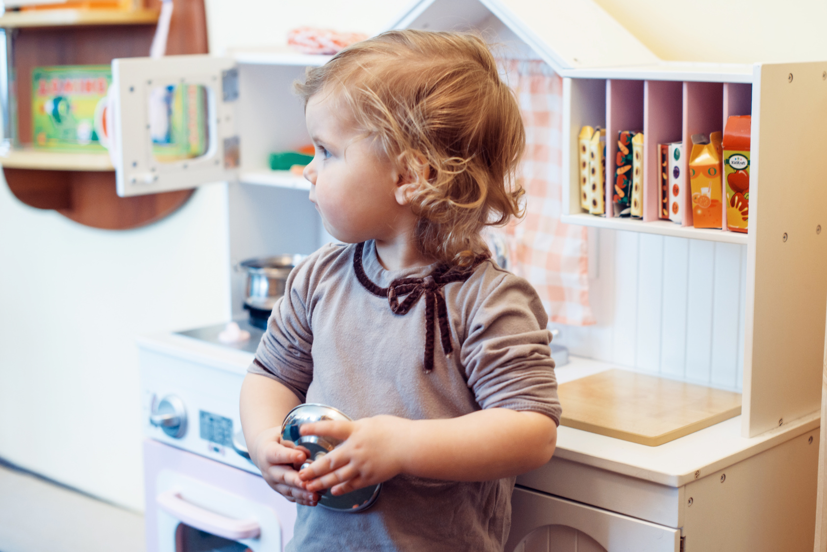 Kleines Mädchen steht an der Spielküche