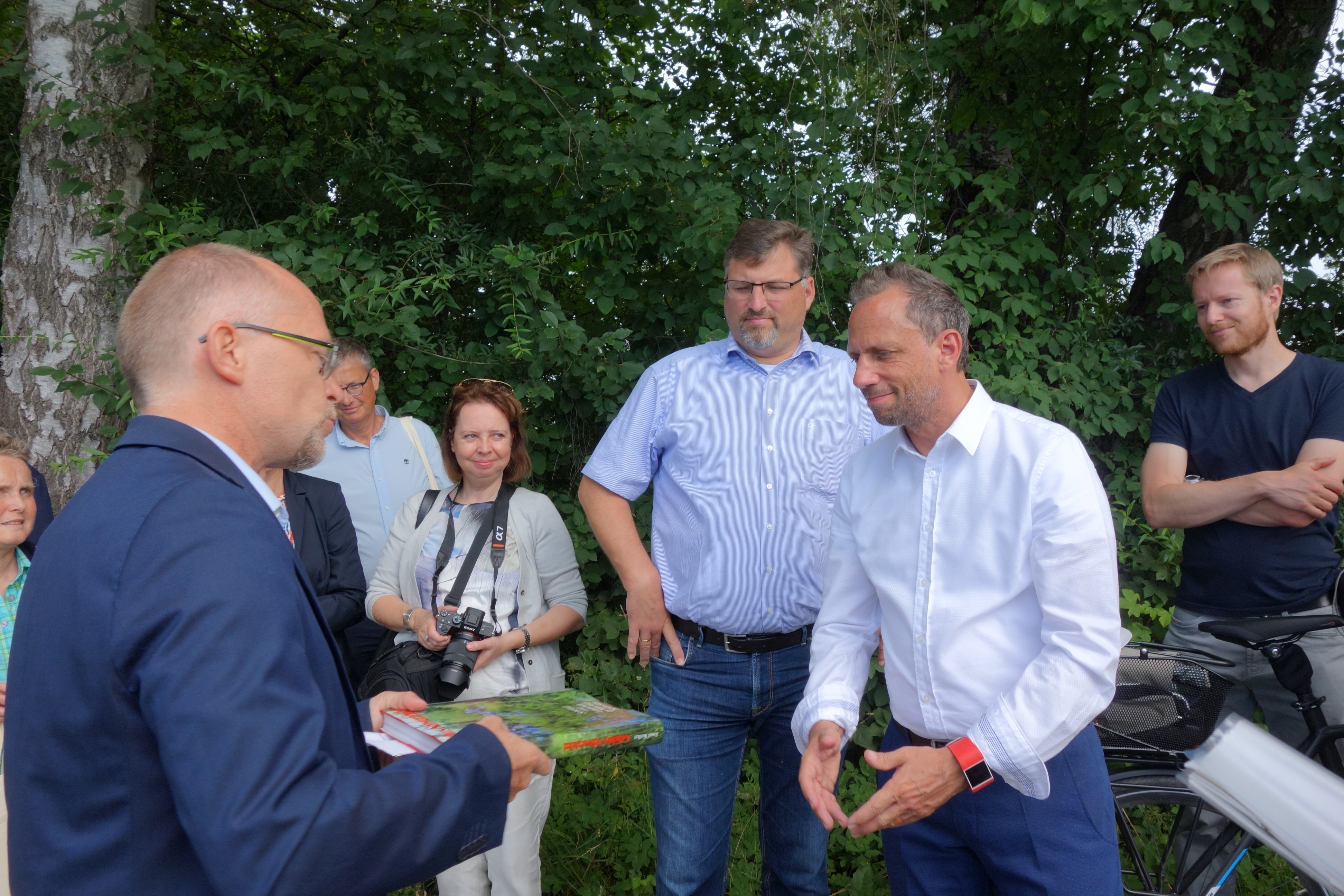 Der 2. Bürgermeister von Karlsfeld Stefan Handl überreicht dem Umweltminister das Schwarzhölzl-Buch von Josef Koller