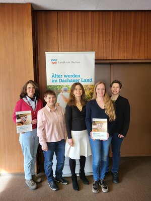 Bild vergr&ouml;&szlig;ern: Die Frauen der Arbeitsgruppe stehen vor einem Roll-up und haben den neuen Ratgeber in der Hand