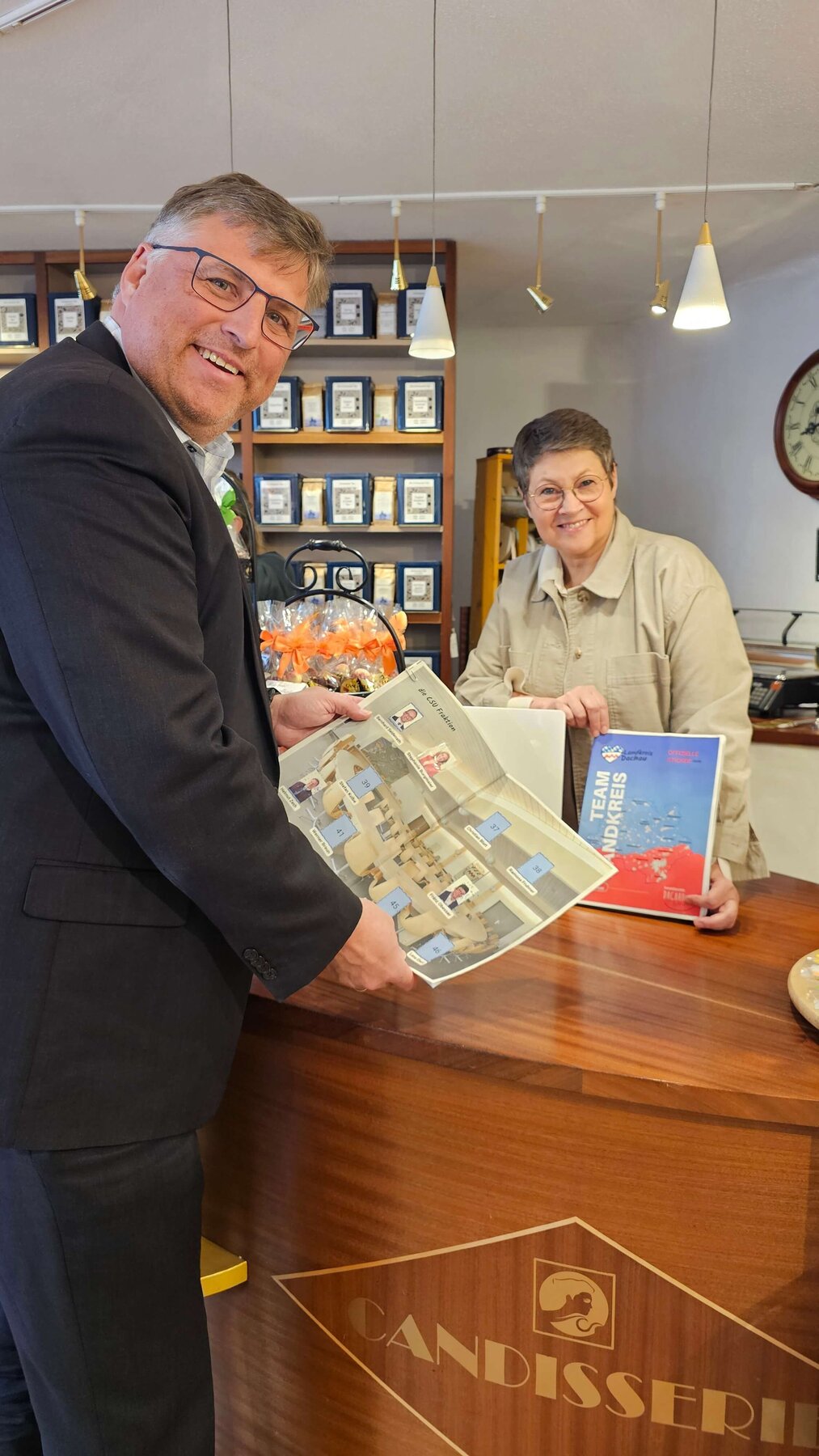 Landrat Stefan Löwl und Isabel Seeber, Vorstand Dachau Handelt mit dem neuen Stickeralbum.