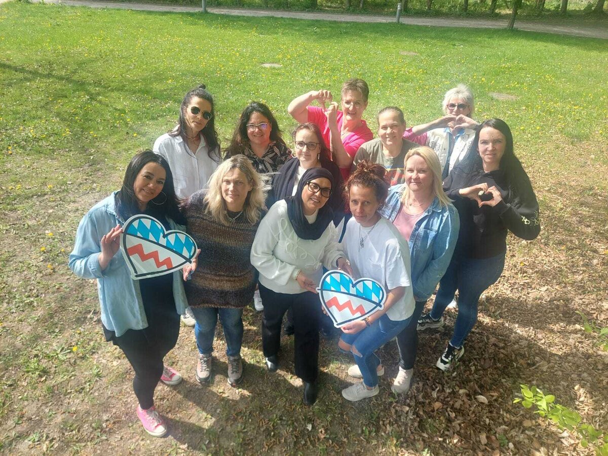Eine Gruppe Frauen, die das rot-blaue Landkreis Herz in Händen halten 