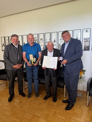 Bild vergr&ouml;&szlig;ern: Von links nach rechts: Helmut Zech, ehemaliger Bürgermeister der Gemeinde Pfaffenhofen a. d. Glonn, Martin Braun jun, Martin Braun sen. und Landrat Stefan Löwl bei der Übergabe des Ehrenzeichens des Bayerischen Ministerpräsidenten an Martin Braun sen.