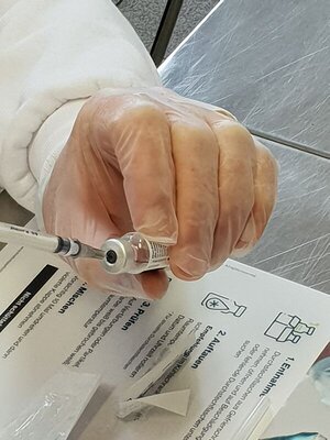 Spritze wird mit Impfstoff aufgezogen