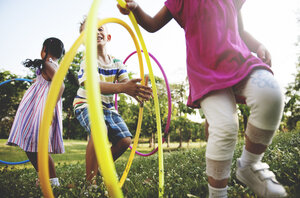 Kinder spielen mit Hulahupreifen