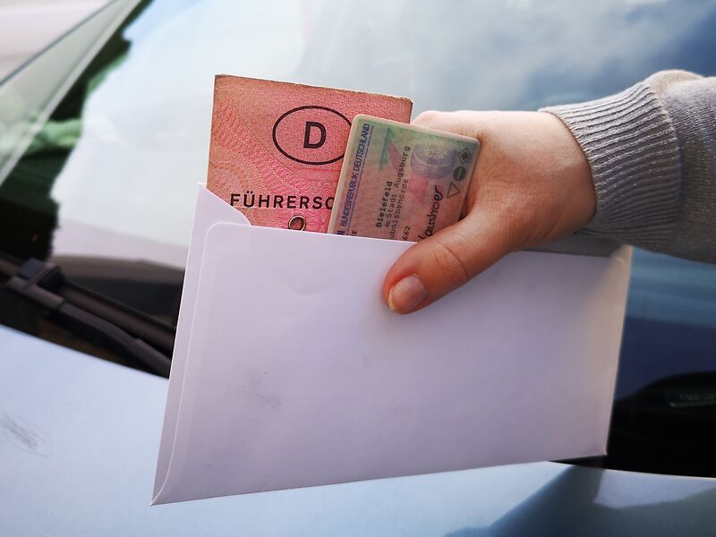 Rosa Führerschein und Kartenführerschein in einem Kuvert.