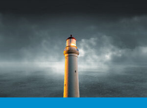 Ein Leuchtturm vor einem wolkenverhangenen, dunklen Himmel.