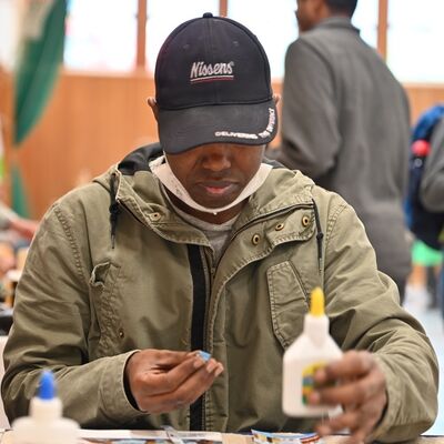 Bild vergr&ouml;&szlig;ern: Herr Diallo zeigt wei man Taschen aus Papier kunstvoll gestalten kann